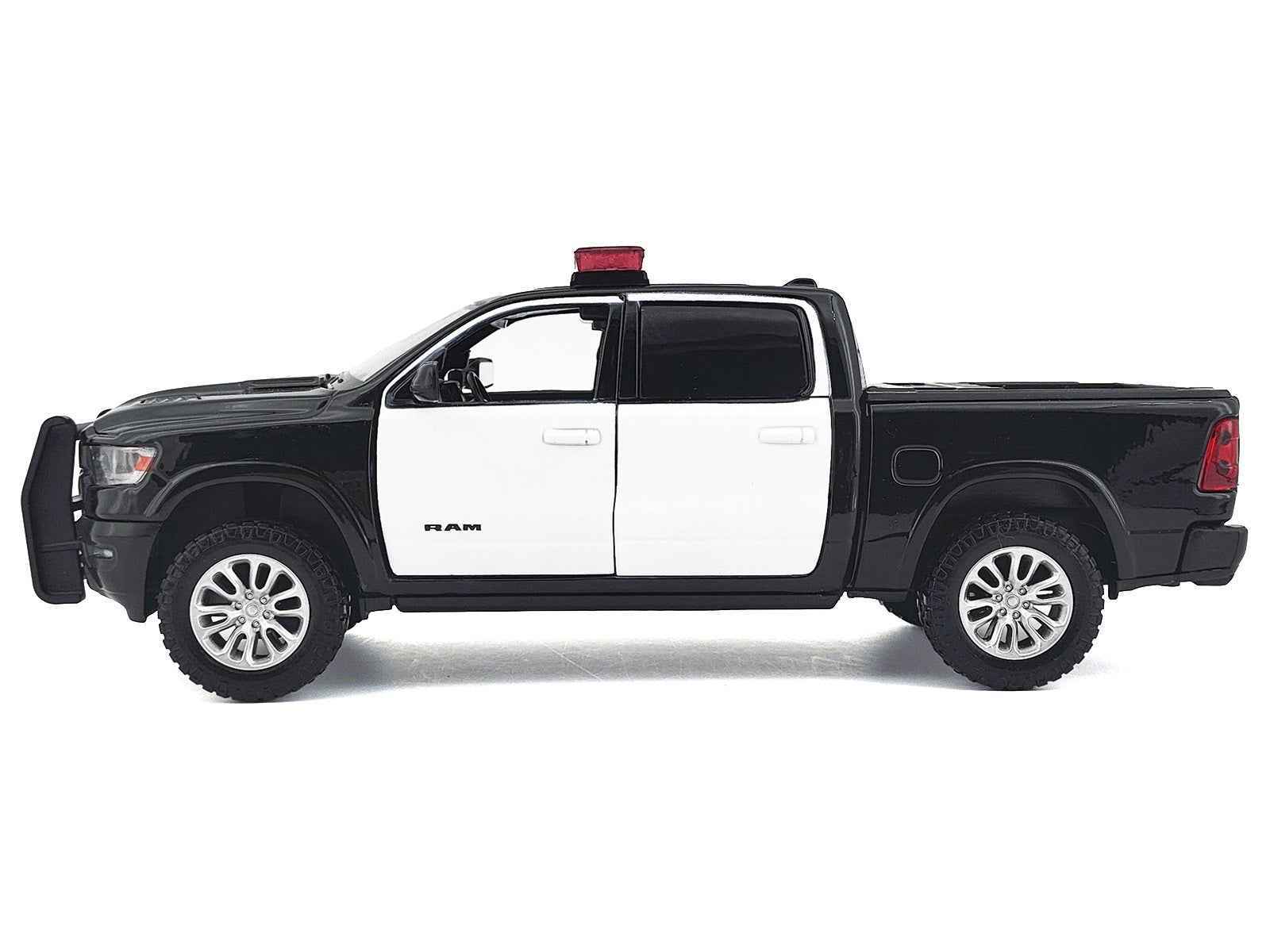 Black and white 1:27 scale diecast pickup truck side view with roof light bar