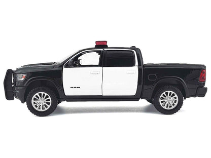 Black and white 1:27 scale diecast pickup truck side view with roof light bar