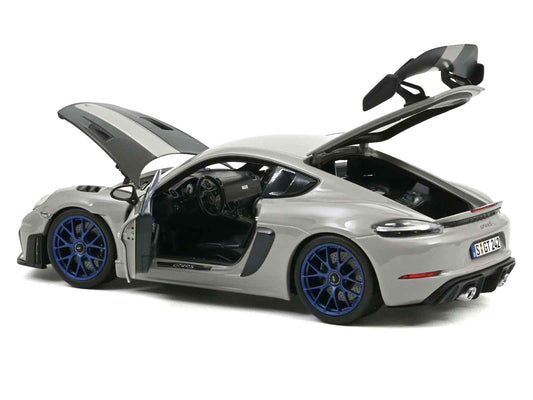 Chalk gray diecast sports car model with open hood and blue front wheels