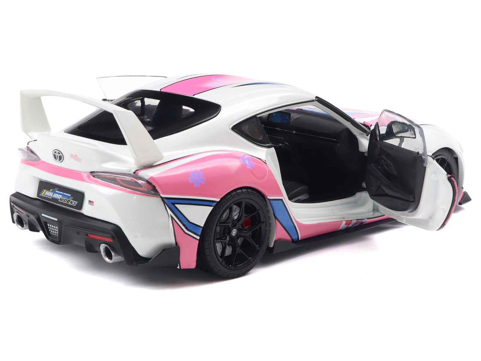 White diecast sports car with pink and blue graphics, black wheels, open driver door