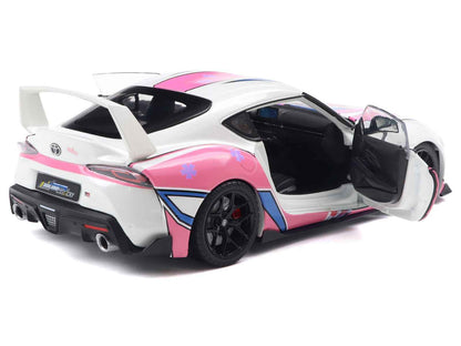 White diecast sports car with pink and blue graphics, black wheels, open driver door