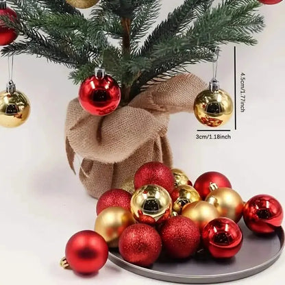 Red and gold sparkling Christmas bauble ornaments on a gray tray with hanging caps