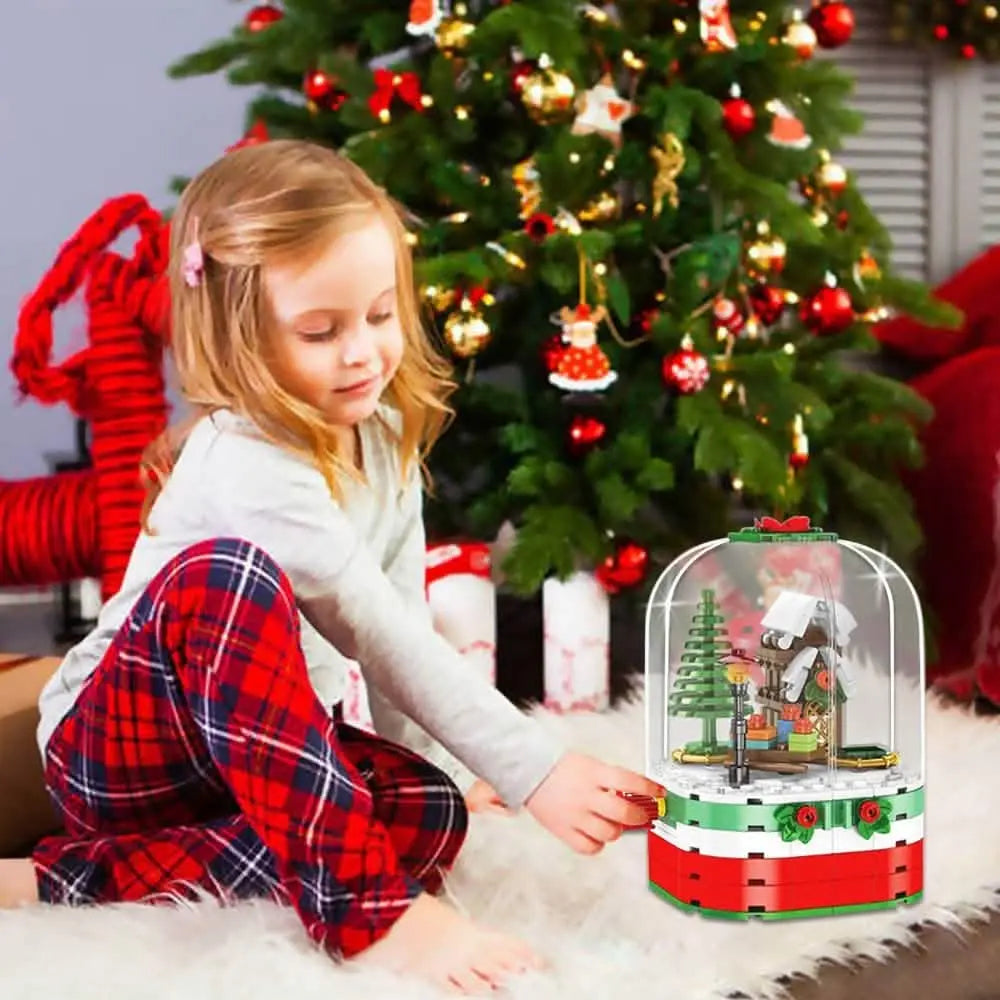 Child kneeling with a Christmas building blocks set in a clear dome on the floor