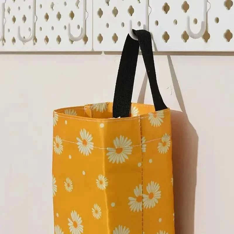 Yellow daisy-print hanging trash storage bag with black handle
