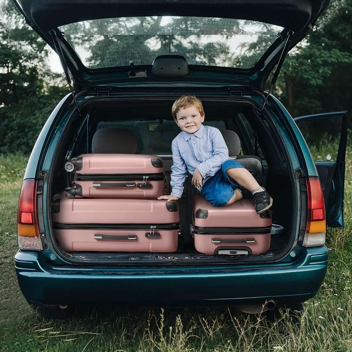 Pink hard shell luggage set stacked in open car trunk