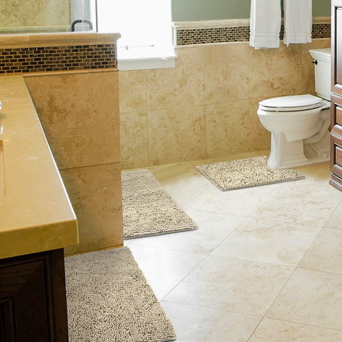 Beige 3-piece chenille bathroom rug set on floor, including bath mat and toilet mat