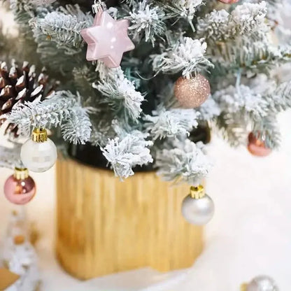 Pink star topper ornament on a frosted Christmas tree with mixed baubles underneath