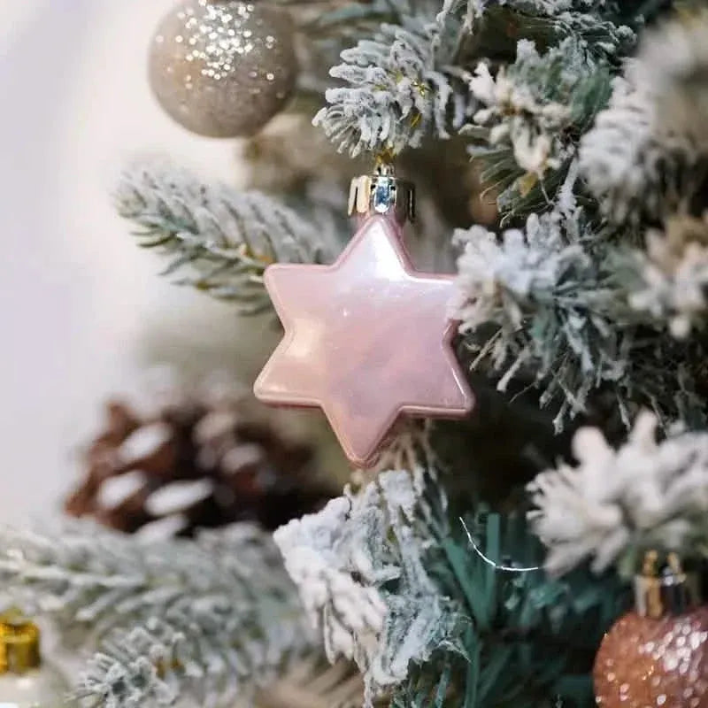 Close-up of a pink glitter star tree topper ornament on a snowy Christmas tree