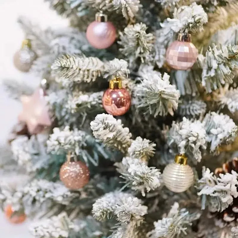 Pink glitter star tree topper with hanging baubles on a decorated Christmas tree