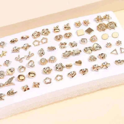 Gold-tone stud earrings set on white card with geometric and floral stud designs