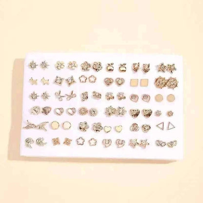 Silver-tone stud earrings set on white card with stars, hearts, and geometric shapes
