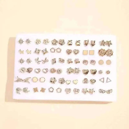 Silver-tone stud earrings set on white card with stars, hearts, and geometric shapes