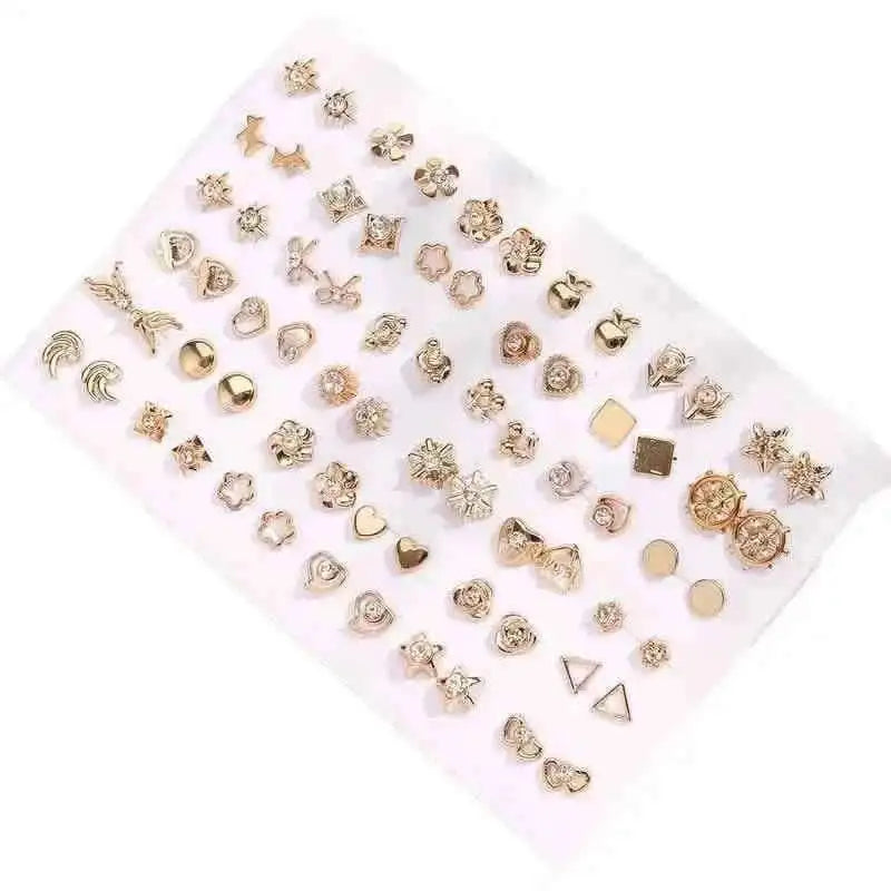Gold-tone stud earrings set on white card with hearts, flowers, and geometric pieces