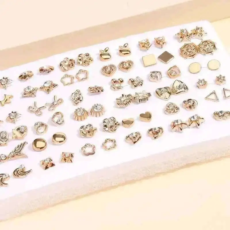 Gold-tone stud earrings set on white card with geometric and floral stud designs