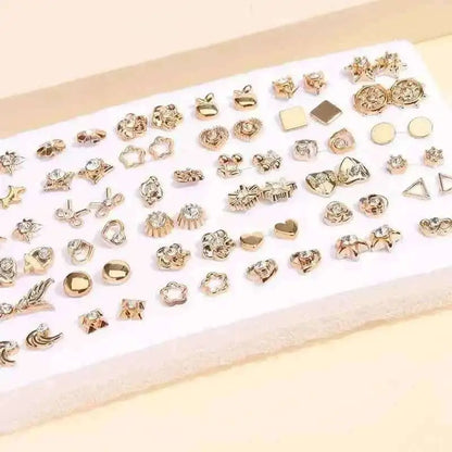 Gold-tone stud earrings set on white card with geometric and floral stud designs