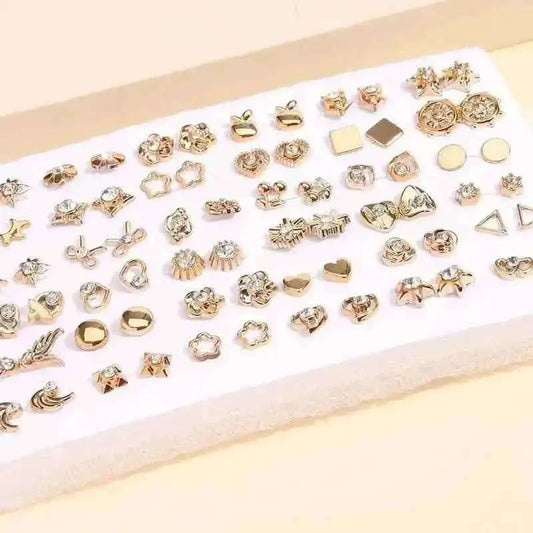 Gold-tone stud earrings set on white card with geometric and floral stud designs