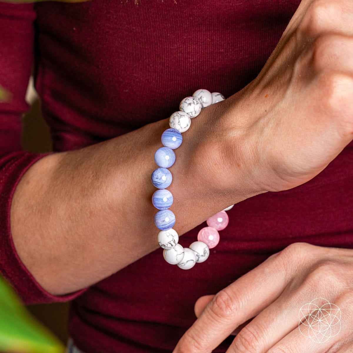 Beaded bracelet on wrist with pink, white, and light blue round stones