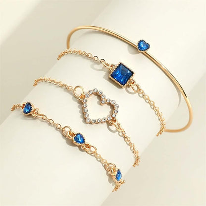 Gold-tone bracelet set with blue heart and square rhinestone charms and ring bangle.