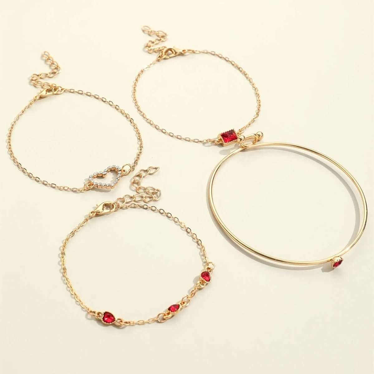Gold-tone bracelet set with red heart rhinestone charms and ring-style cuff bangle.