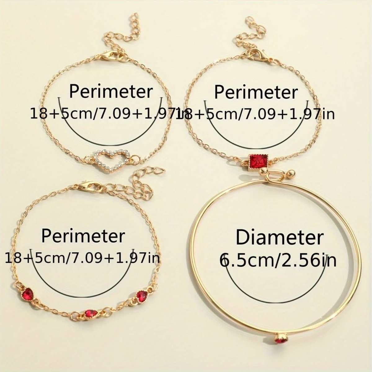 Gold-tone bracelet set with red and clear rhinestone heart and square charms laid out.