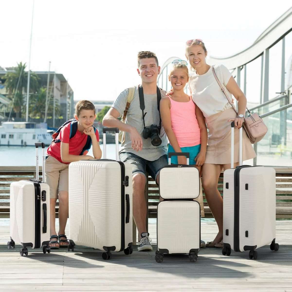 White hard-shell spinner luggage set with telescoping handles, 5 pieces in use