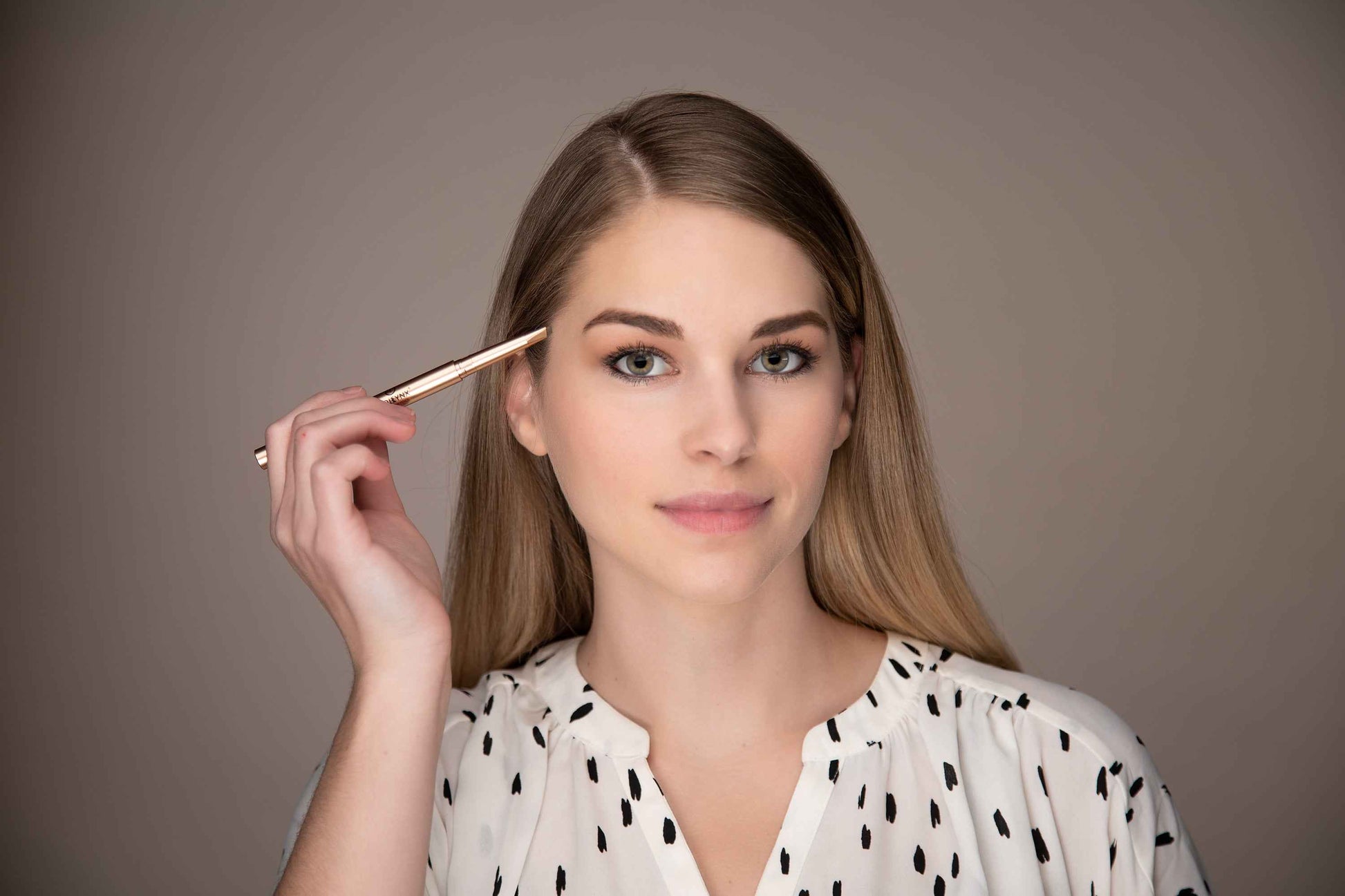 Eyebrow pencil held near eyebrow on model, shown at side profile
