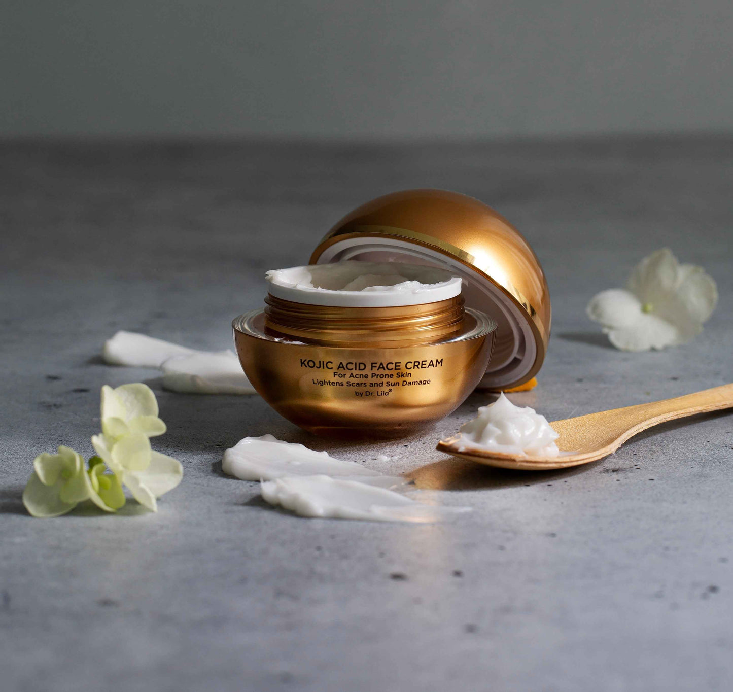 Amber face cream jar with gold cap tipped open, showing white cream inside