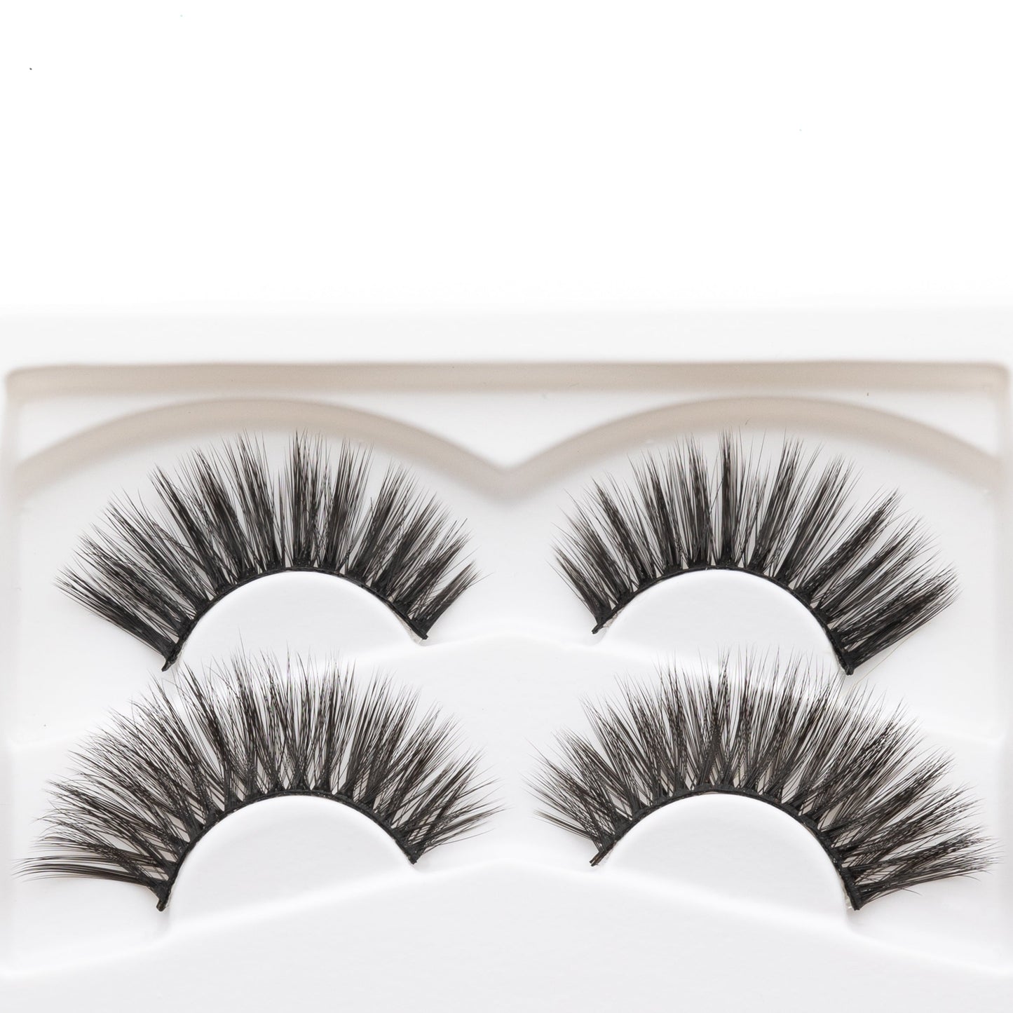 Close-up of four reusable false eyelashes in a white molded tray