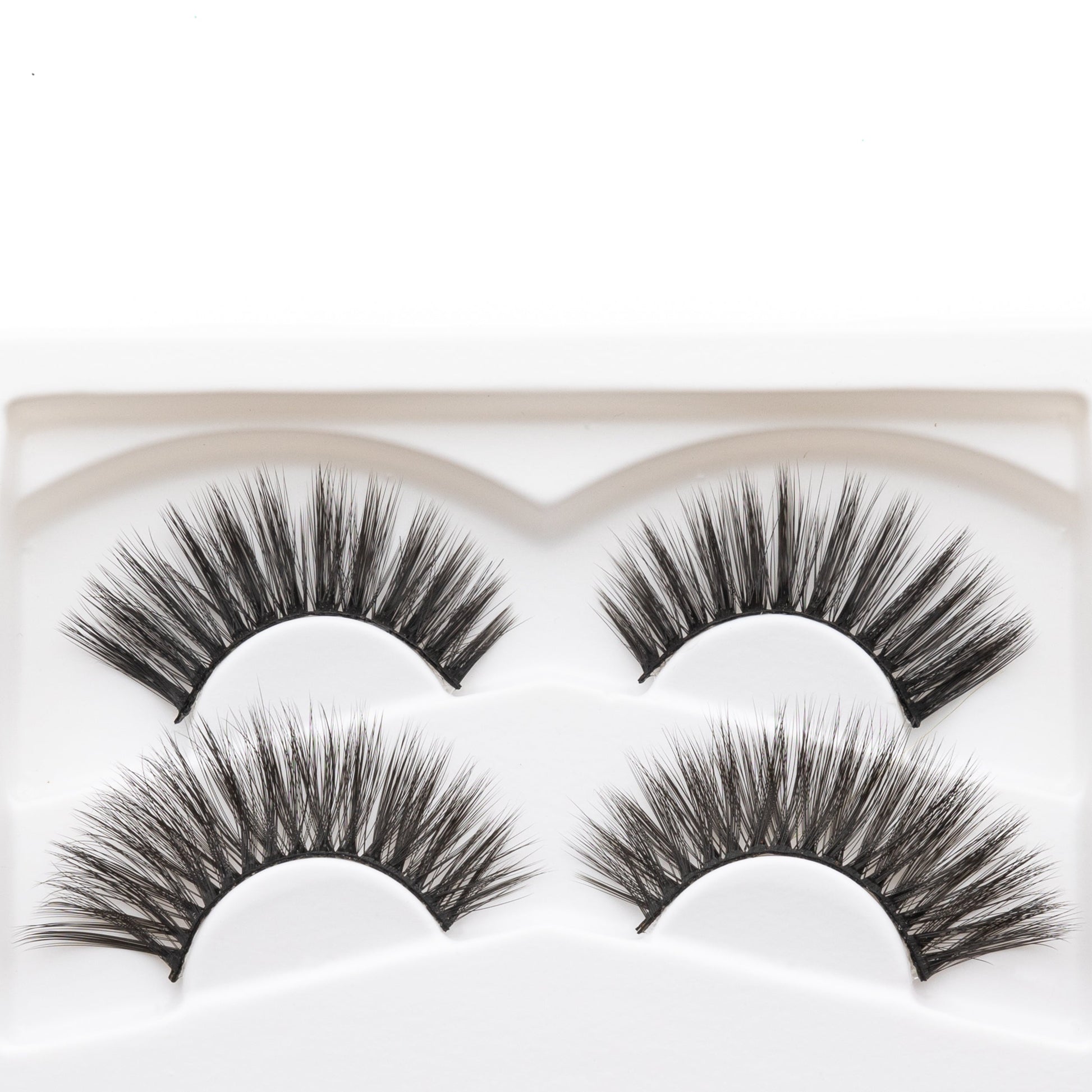 Close-up of four reusable false eyelashes in a white molded tray