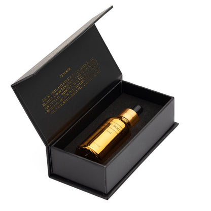 Skincare set gift box with gold serum bottle inside, black packaging