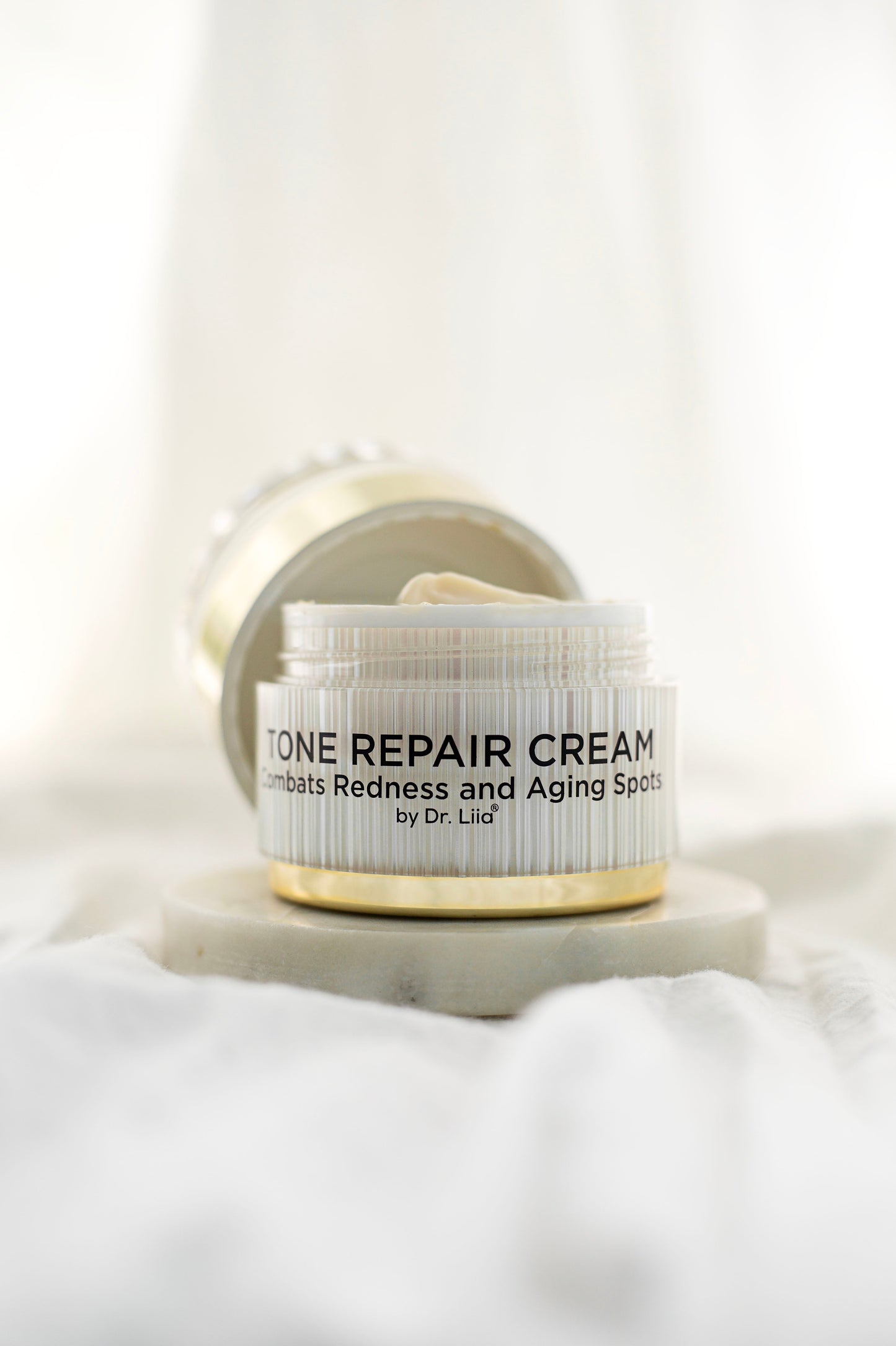 Tone Repair Cream jar with lid flipped open, showing inner rim