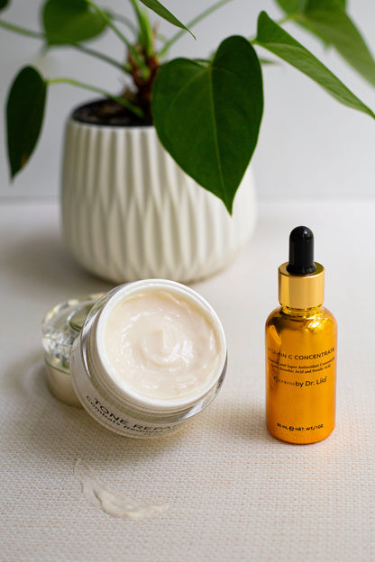 Opened tone repair cream jar with white cream and amber vitamin C concentrate bottle
