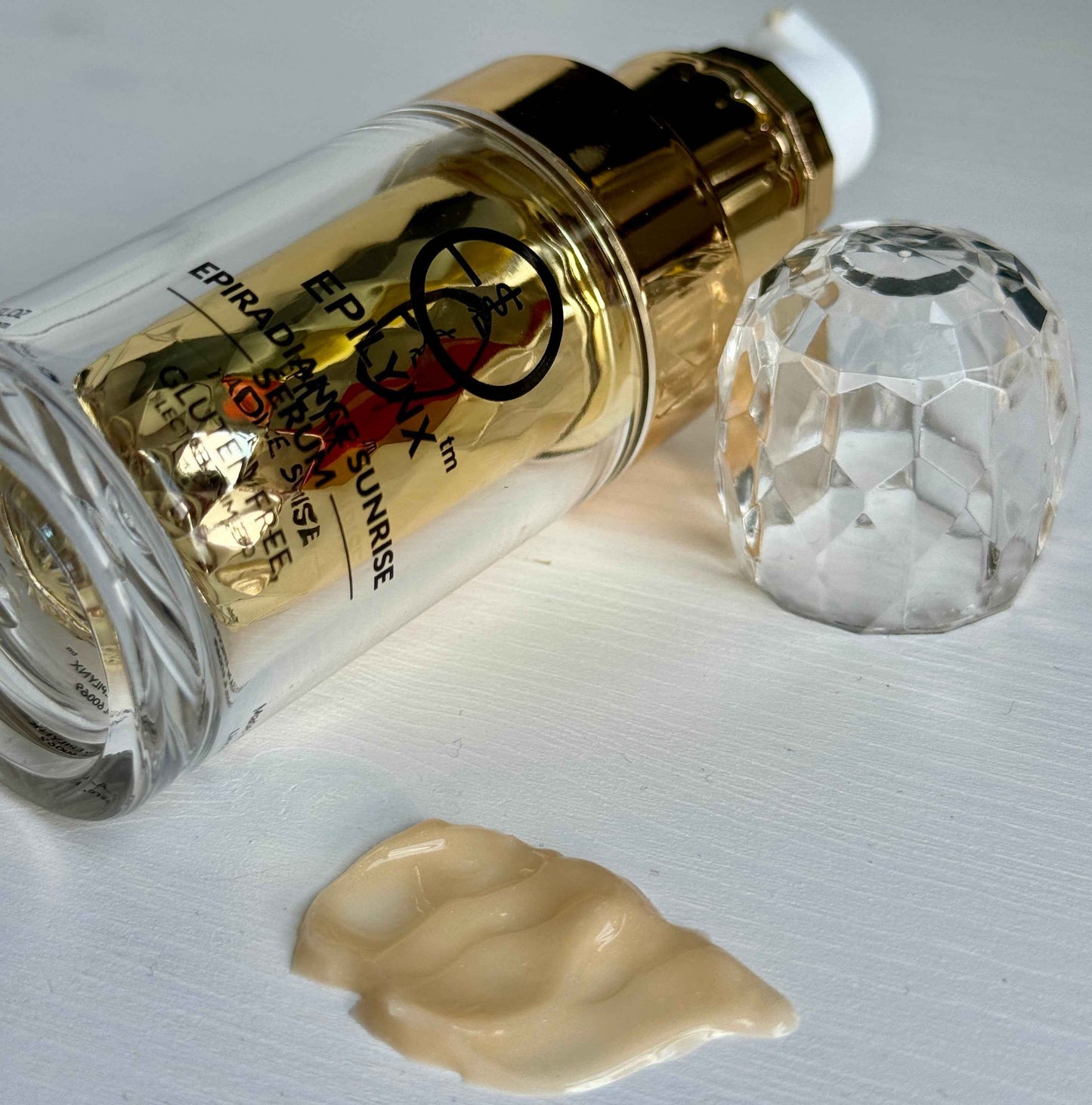 Serum bottle with gold pump and dropper tip, shown with dollop of gel.