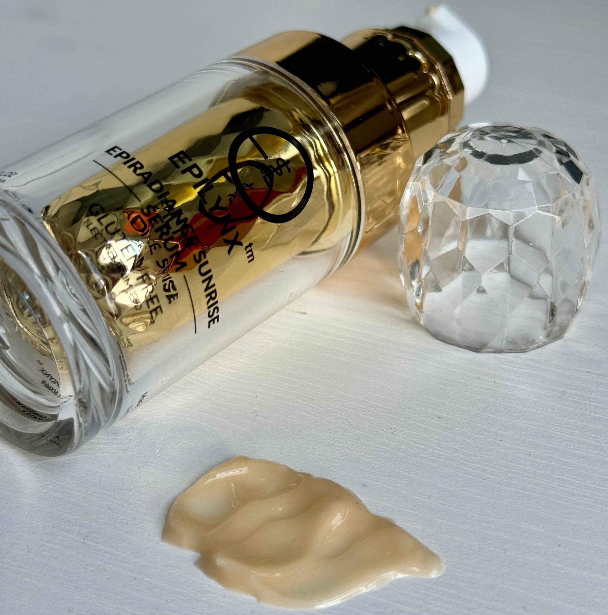 Serum bottle with gold pump and dropper tip, shown with dollop of gel.