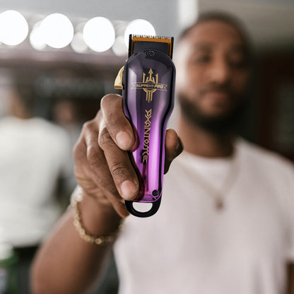 Purple professional hair clipper held upright in a hand, blade facing up