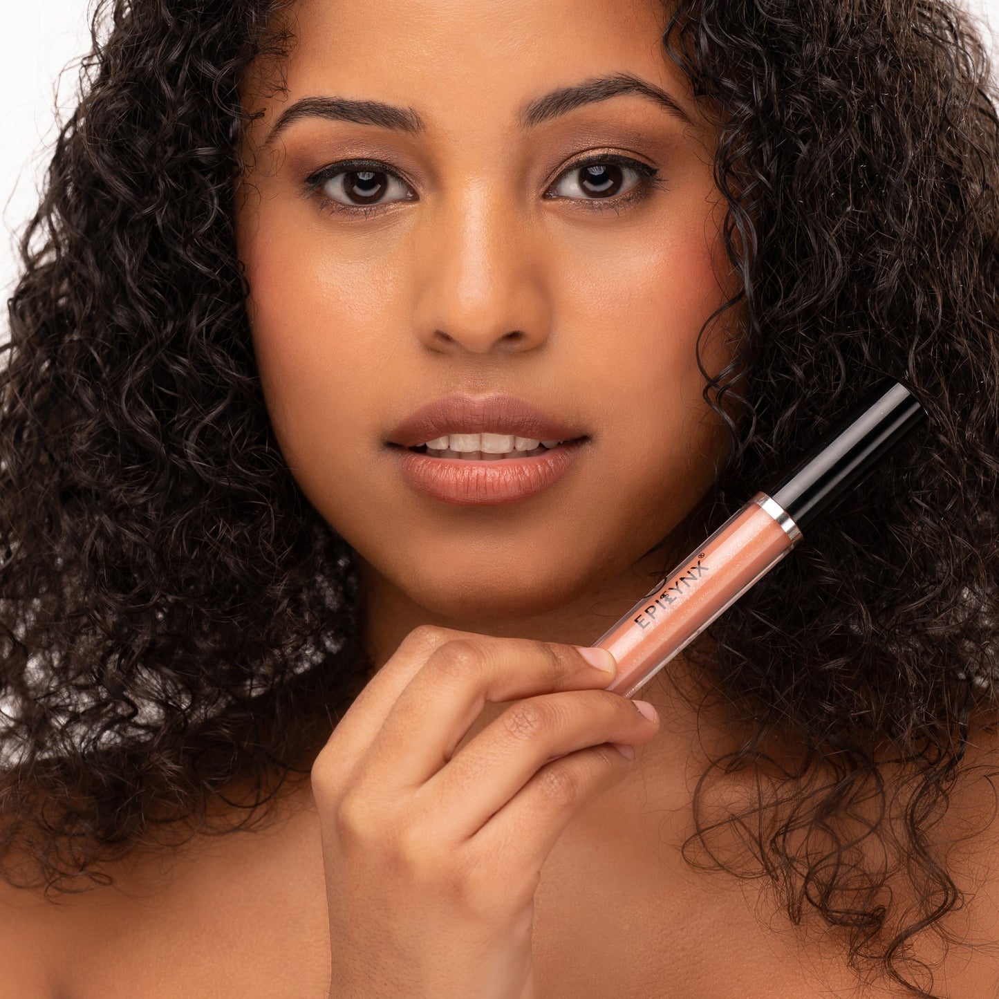 Shine lip gloss on lips with rose-pink tube, applied by hand