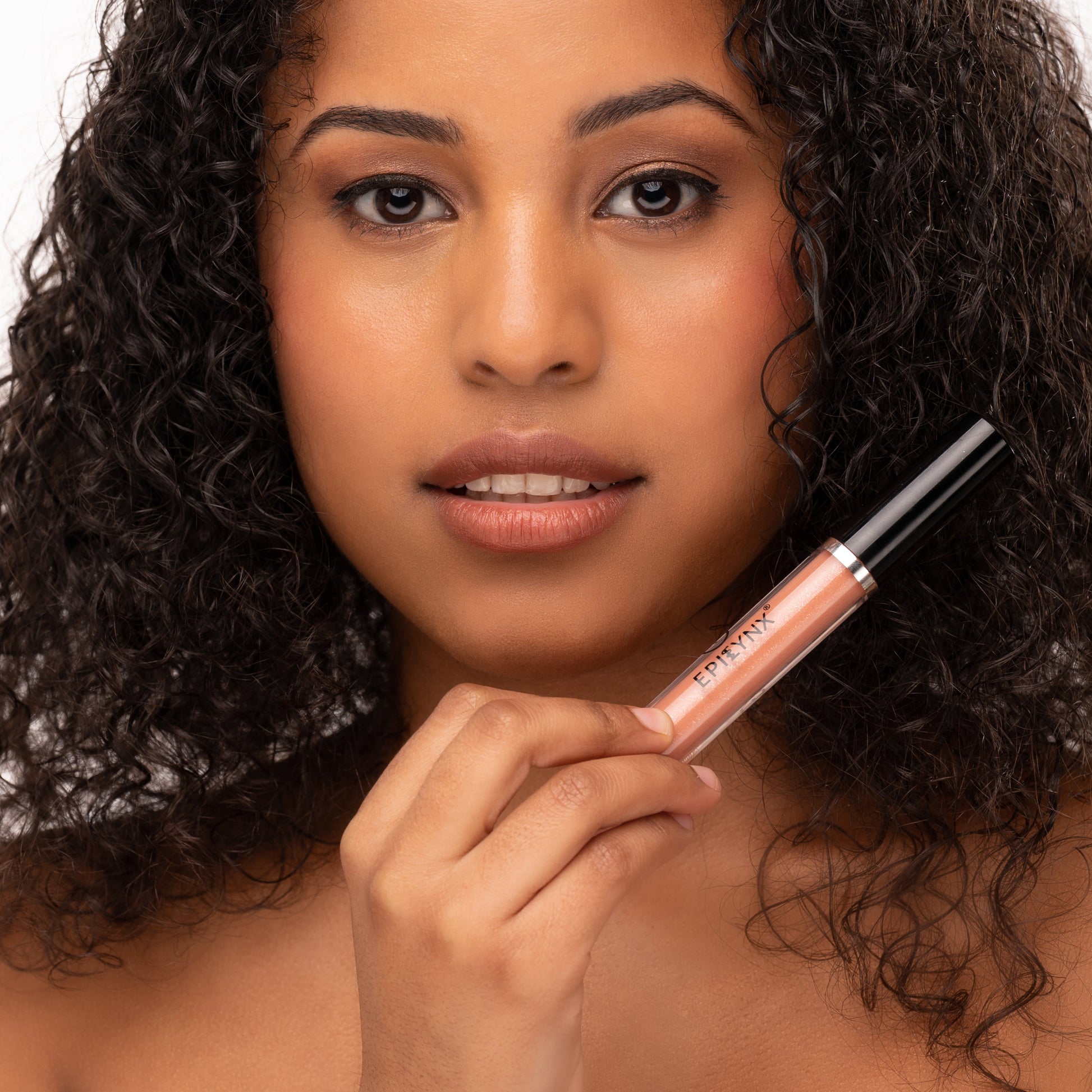 Shine lip gloss on lips with rose-pink tube, applied by hand