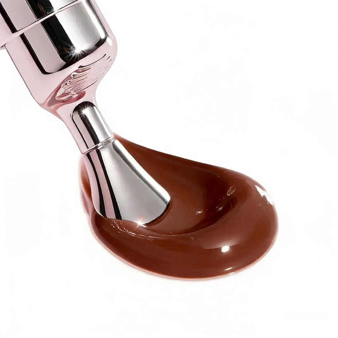 Brown glossy lip treatment flow on applicator tip, with metallic dispenser.