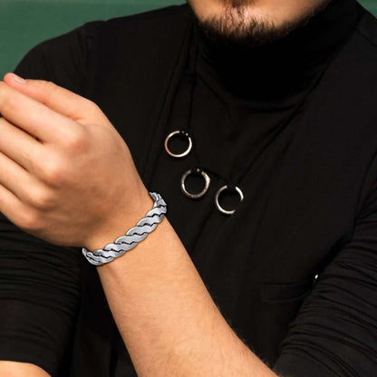 Silver magnetic therapy bracelet on wrist with twisted links and circular magnetic insets