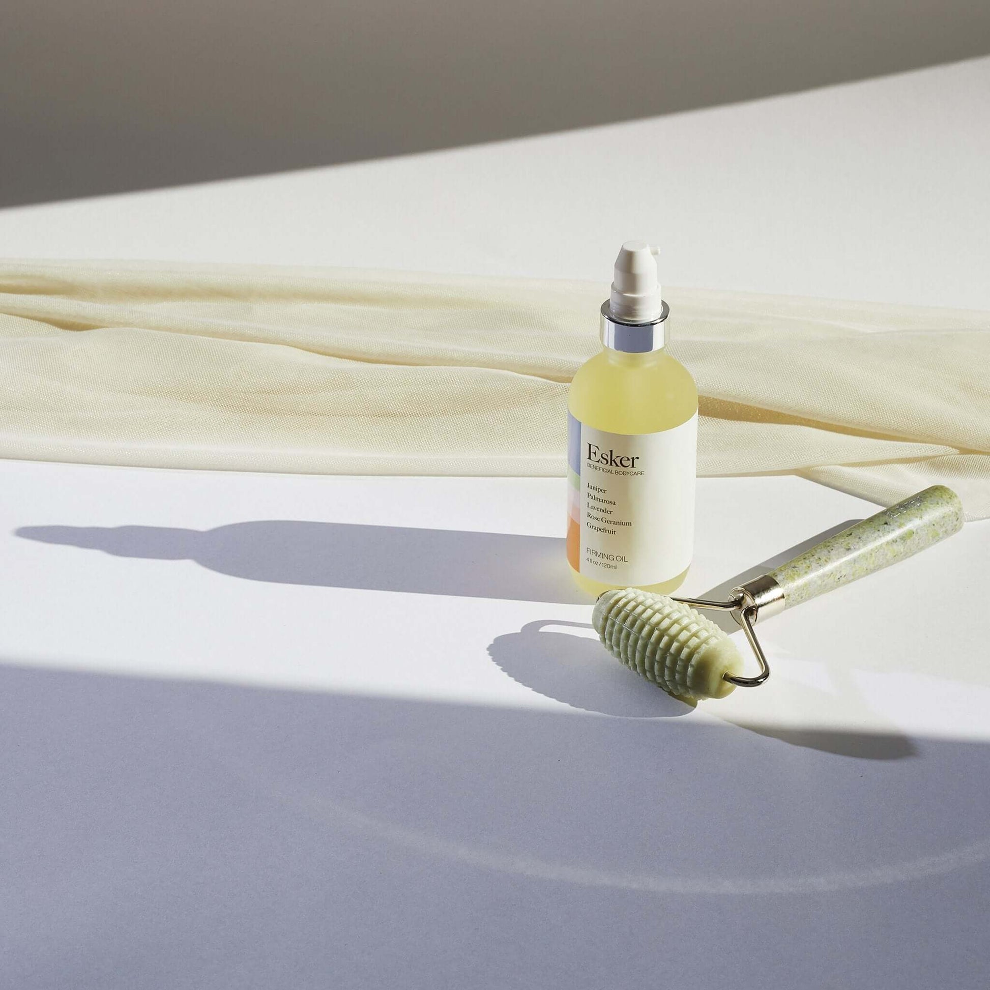 Allover roller with textured light-green head and speckled handle beside lotion bottle
