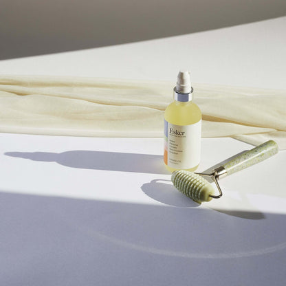 Allover roller with textured light-green head and speckled handle beside lotion bottle