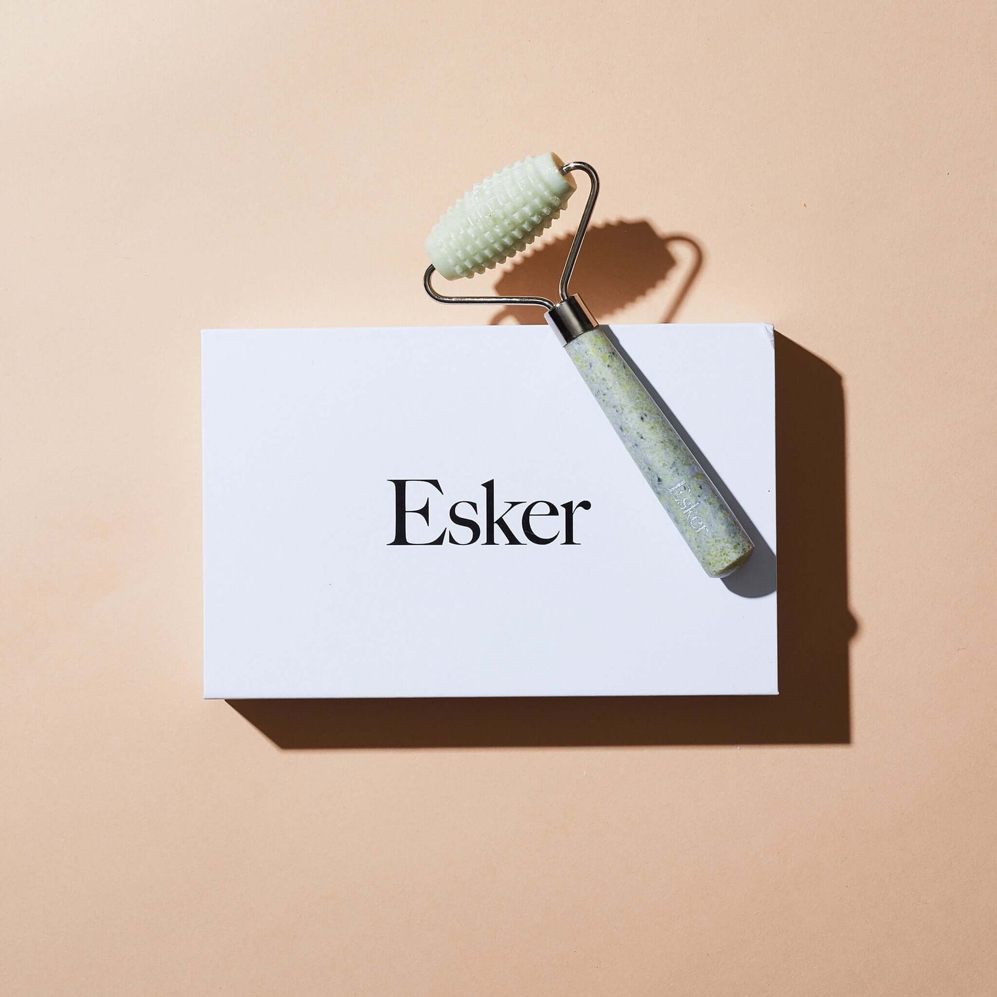 Allover roller resting: textured light-green head and speckled jade-look handle