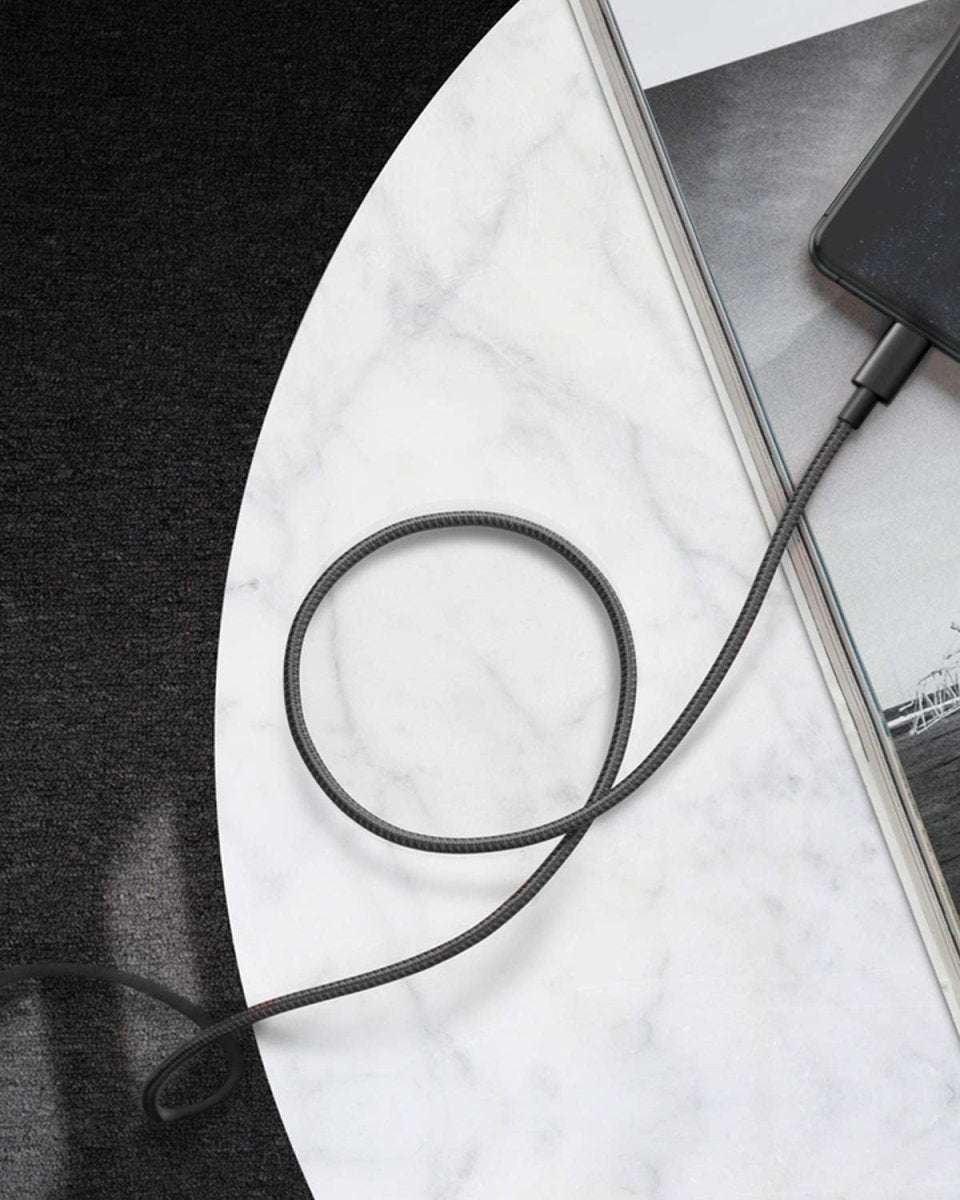 Black USB-C to Lightning cable coiled, showing braided nylon jacket and plug ends