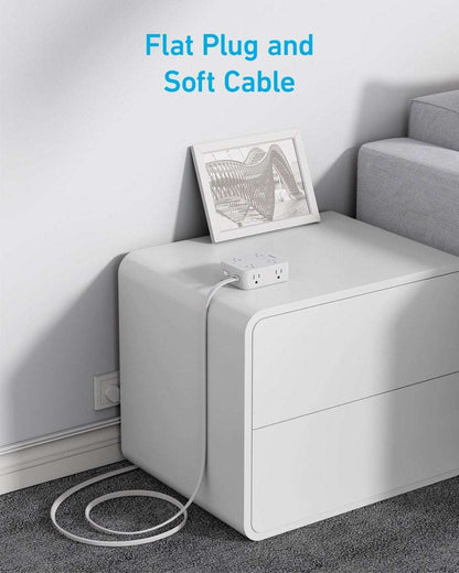 White USB power strip with plug and power cord, near a wall outlet
