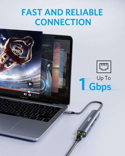 Grey slim USB-C hub with braided cable attached near a laptop USB-C port