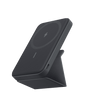 Black magnetic battery dock on a foldable stand, showing charging pad and side port
