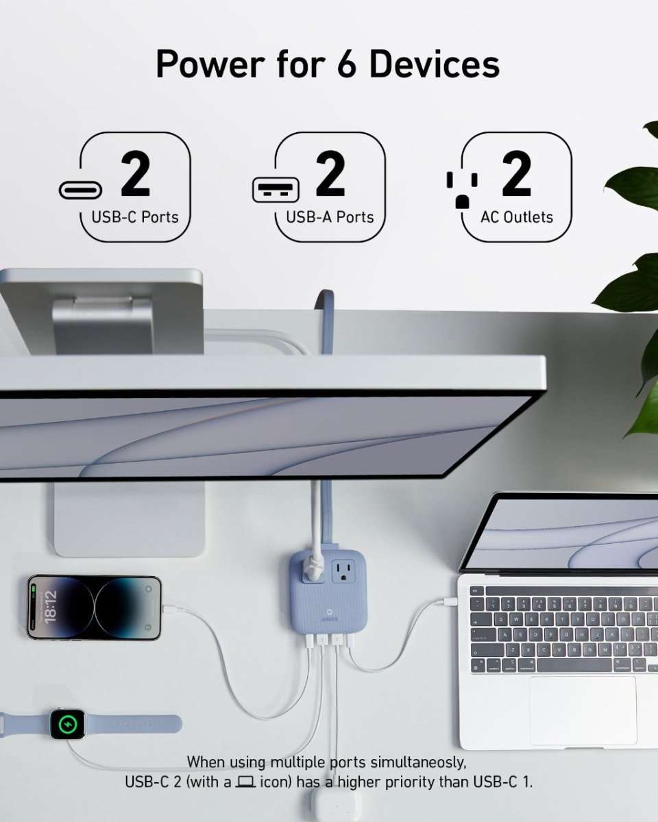 White multi-device charging station with USB ports and AC outlets in use on a desk