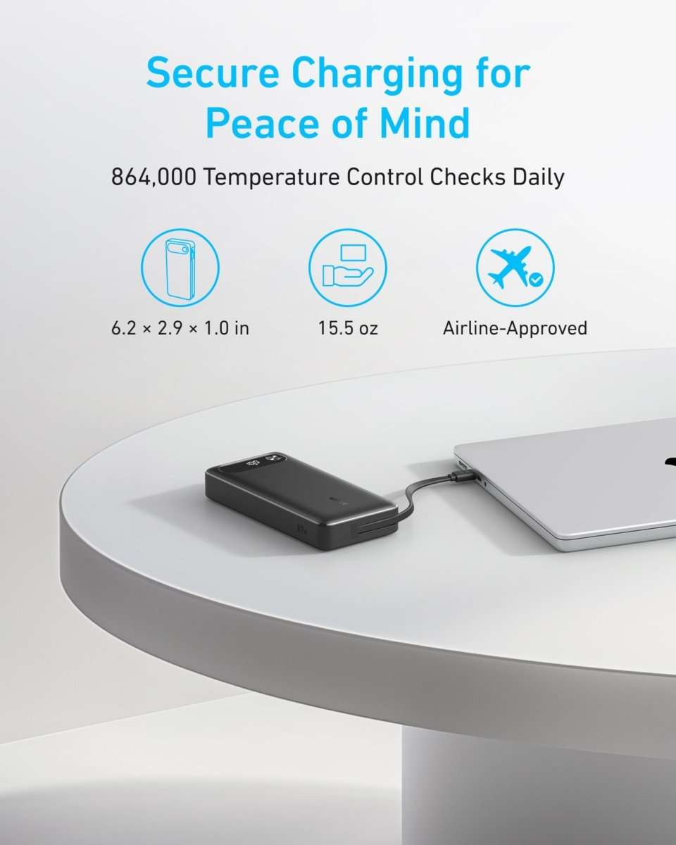 Black power bank with built-in USB-C cable on a table near a laptop