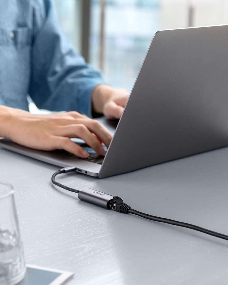Gray USB-C to Ethernet adapter on cable connected at an office desk