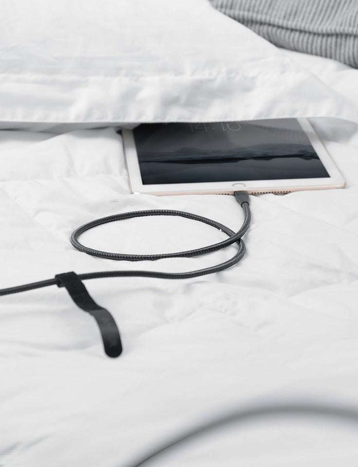 Black braided charging cable coiled with Lightning connector